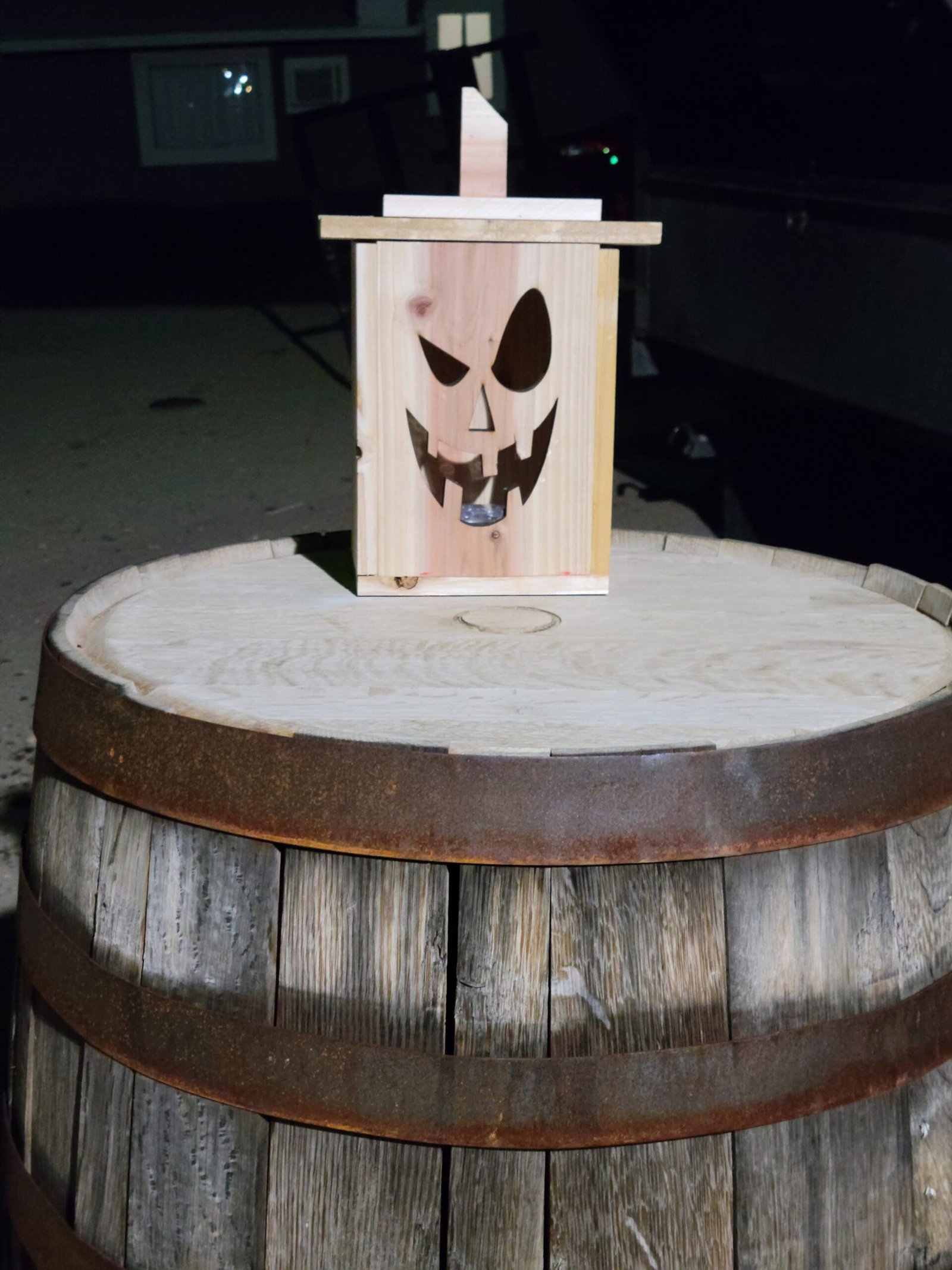 Handmade wooden lantern on whiskey barrel at night